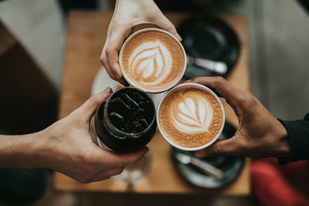 Friends bringing their coffee cups together